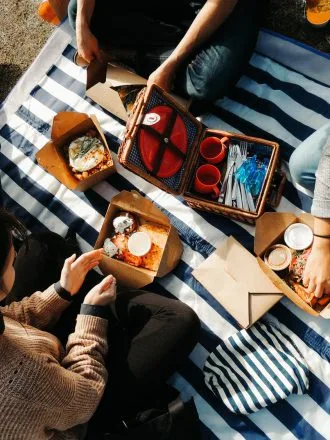 Vue de dessus d’étudiants partageant un repas sur une nappe rayée