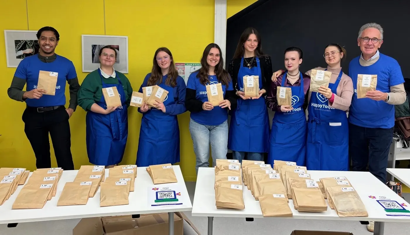 L’équipe de bénévoles HappyToque en tablier bleu prépare des sachets de culottes menstruelles lors d’une distribution à la Maison des Étudiants